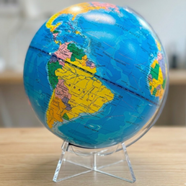 Globo terráqueo político con división por países y base de acrílico transparente sobre escritorio de madera, ideal para estudiantes.